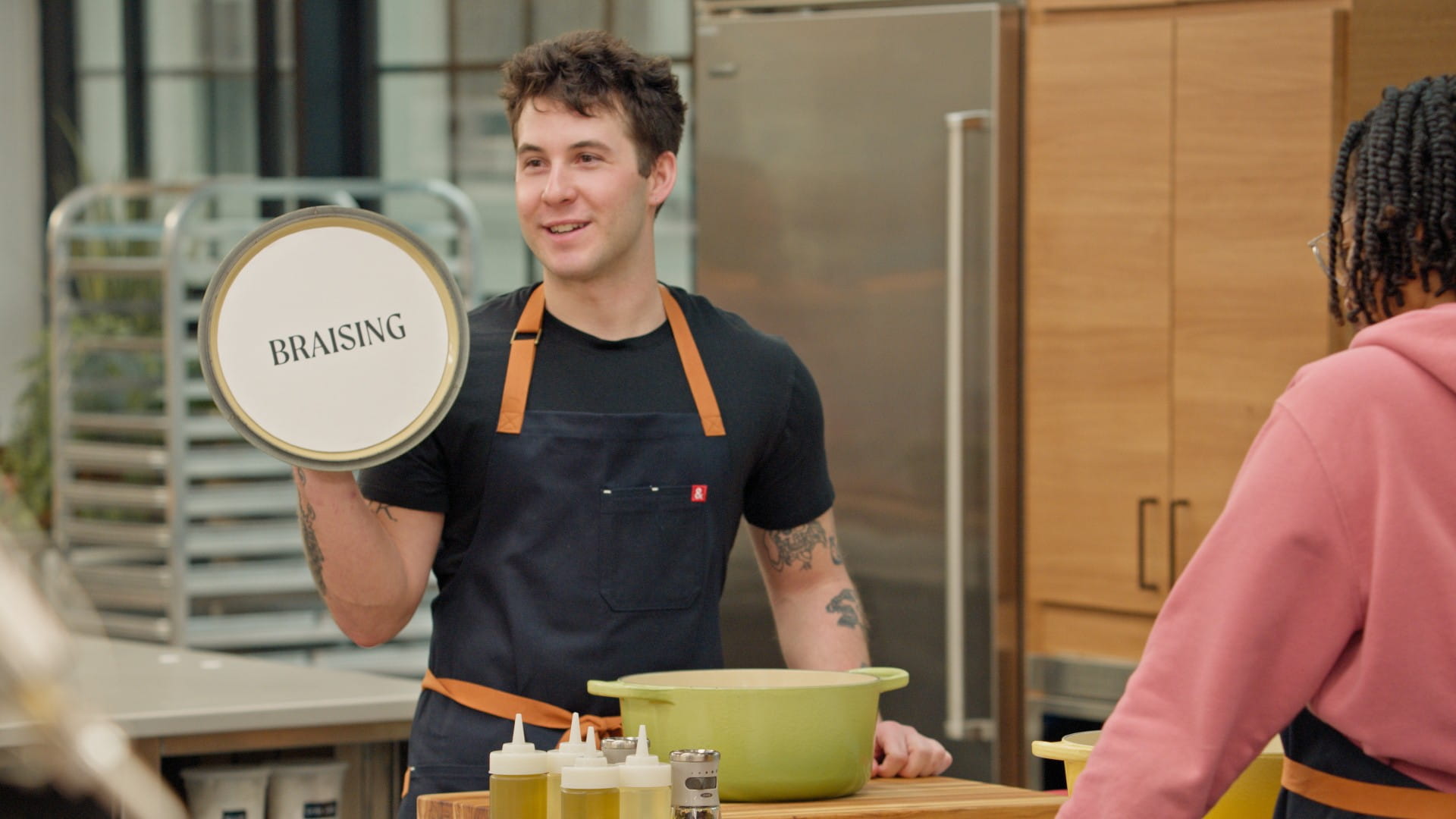 man holding pot lid in kitchen