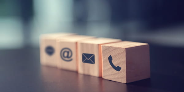 Wood blocks with phone, text, email, and website icons on them.