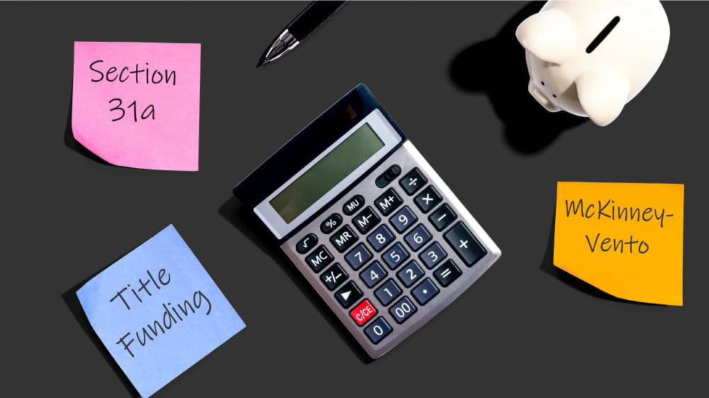 African American woman accountant using calculator while seated at desk with laptop.