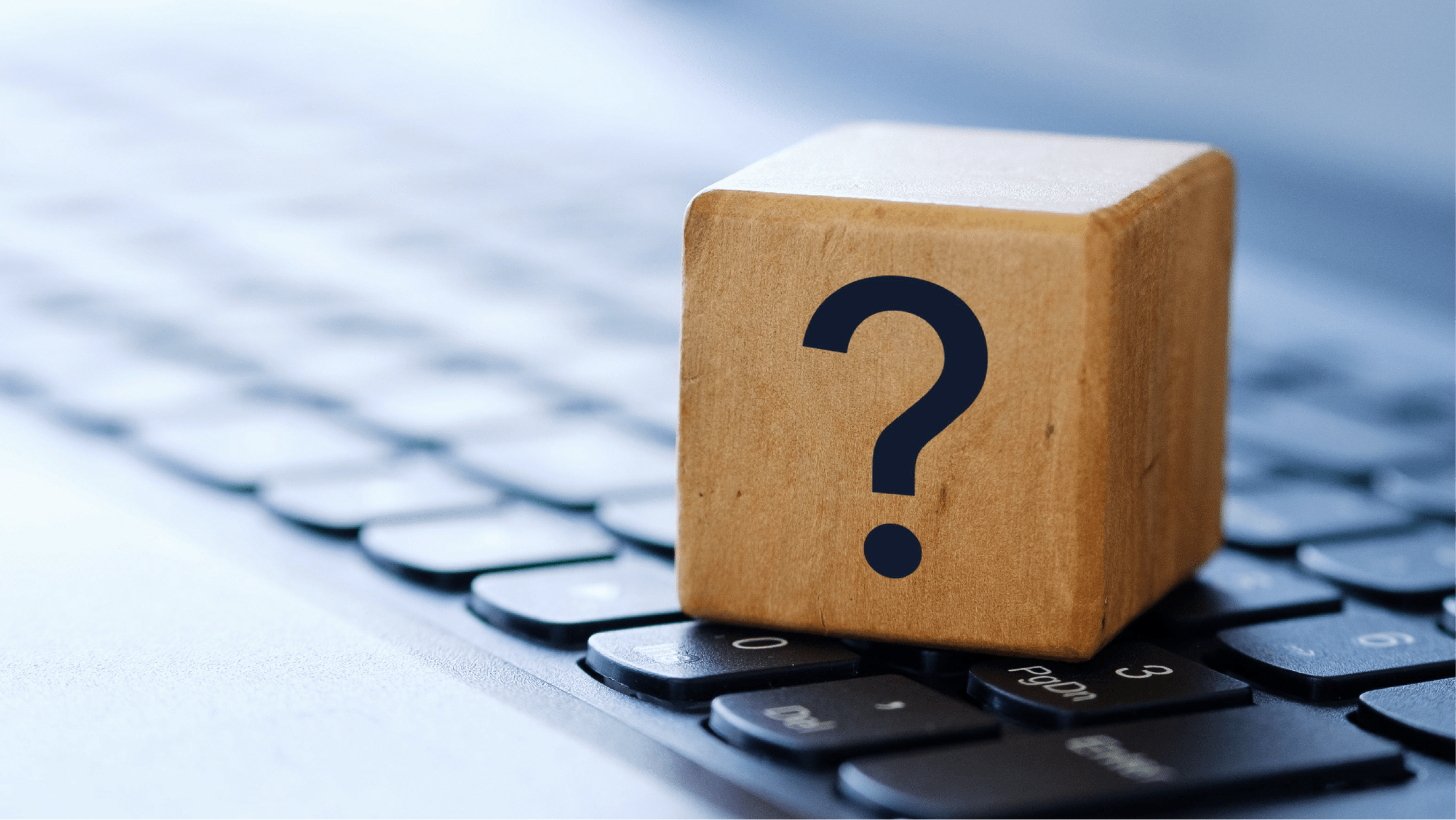 Laptop keyboard with wooden question mark block sitting on it.