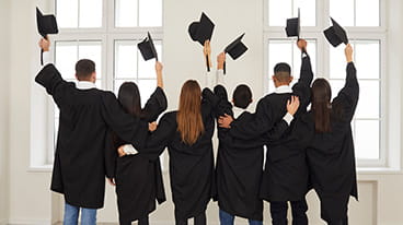 Group of high school graduates with hats raised