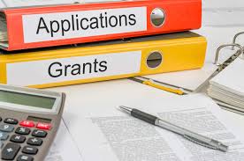 Image of three binders with a calculator, paper, and pen