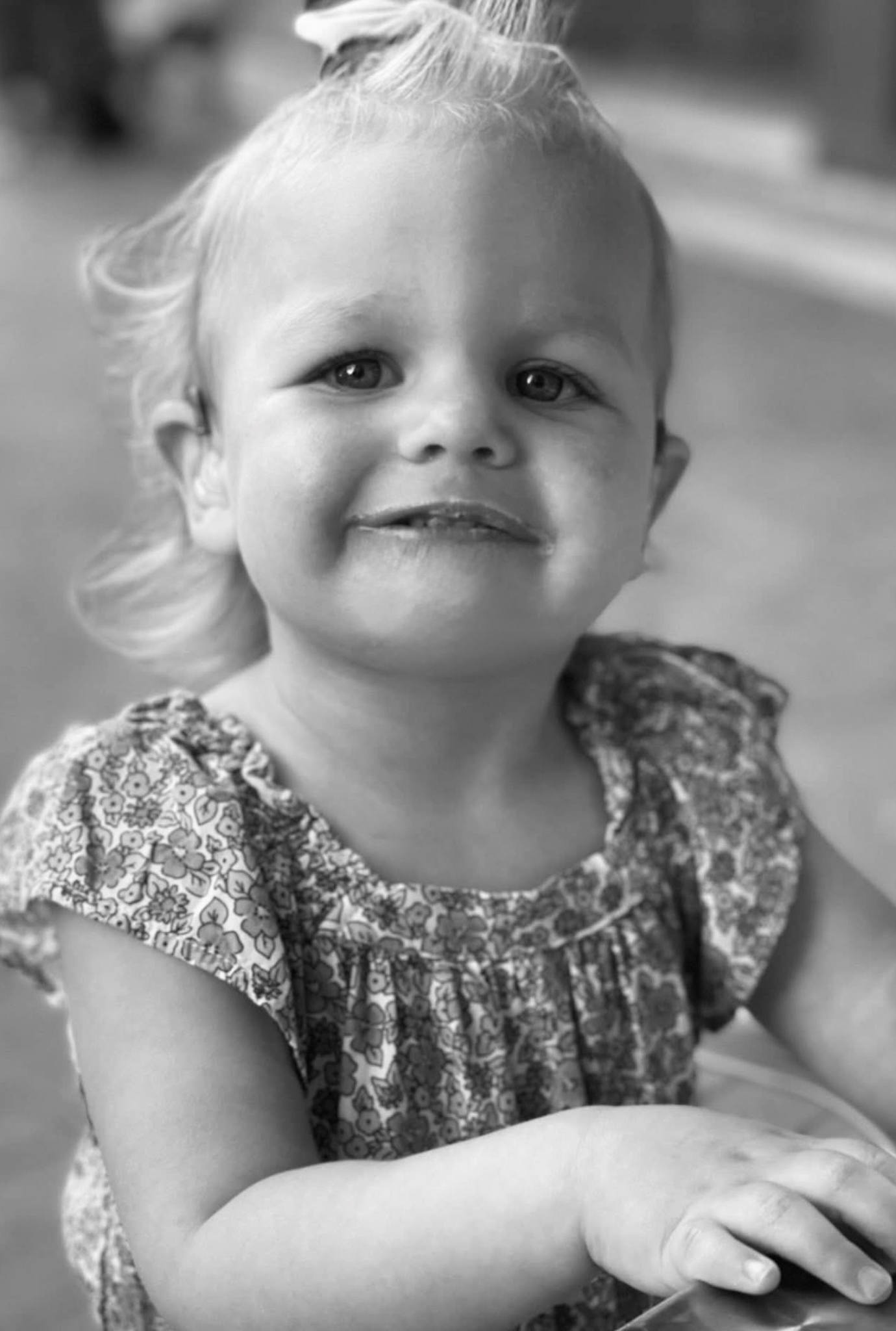 Braelyn, a young girl wearing a floral top, smiles at the camera.