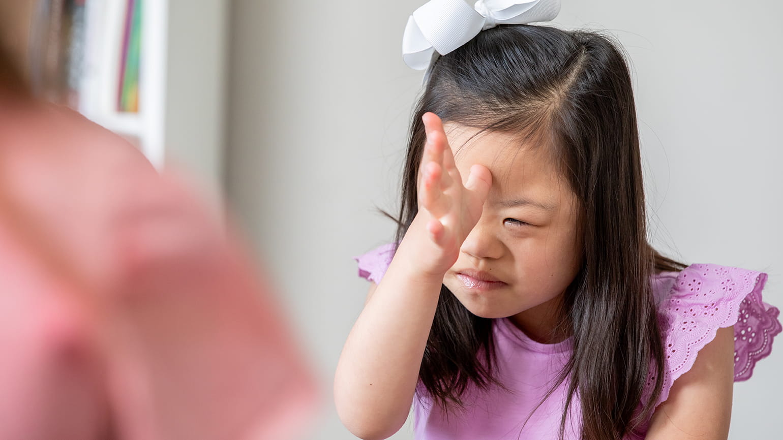 A young girl uses sign language.