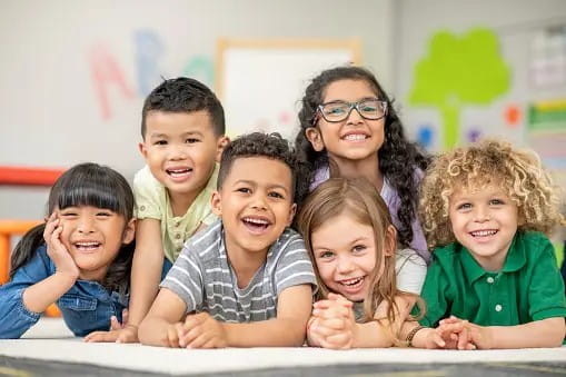 Children laying on the floor smiling