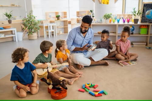 Educator with children on the floor playing instruments