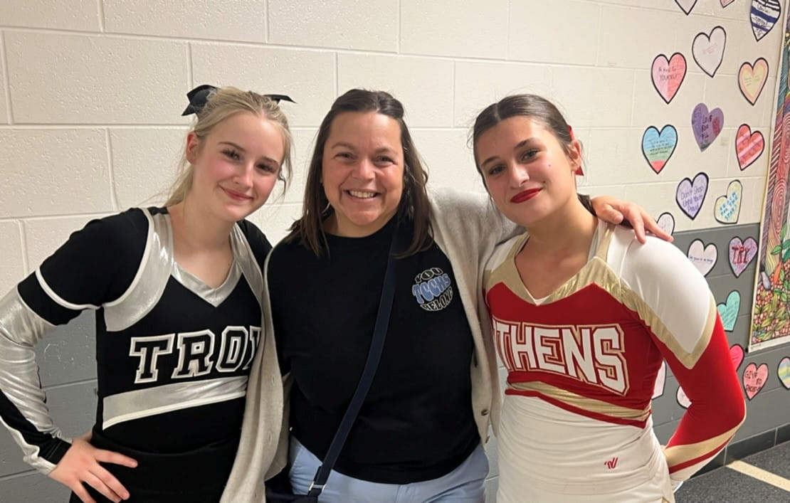 Female educator with 2 female students in cheer suits
