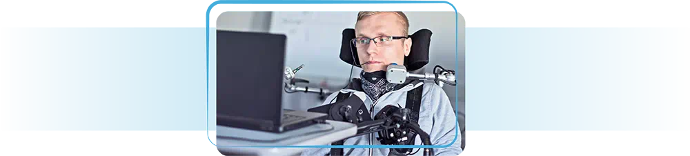 Man in wheelchair working on laptop.