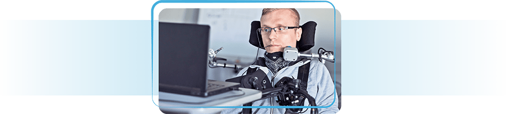 Man in wheelchair working on laptop.