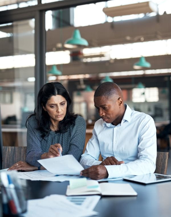 man and woman discussing paper