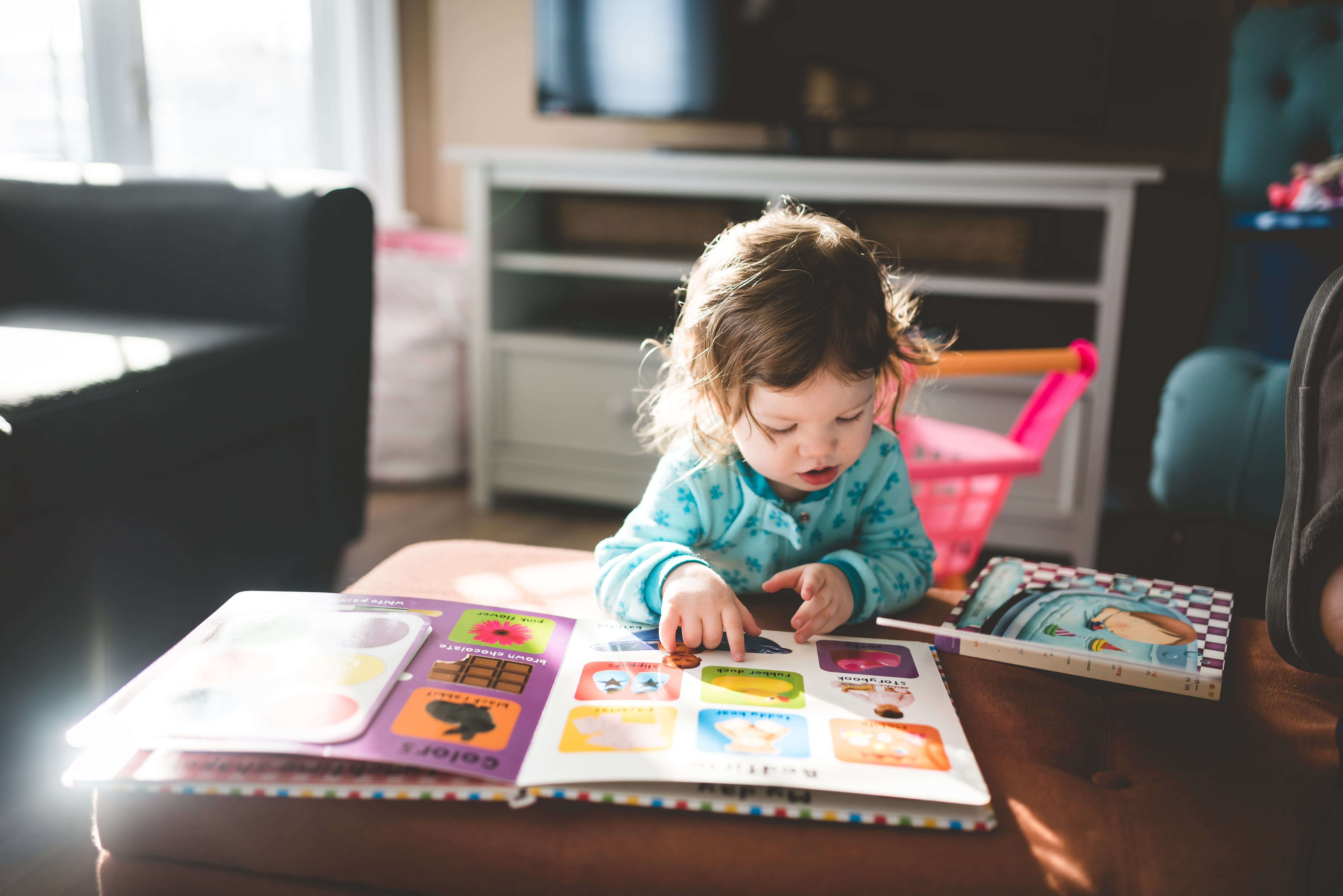 Photo of a toddler looking at a book.