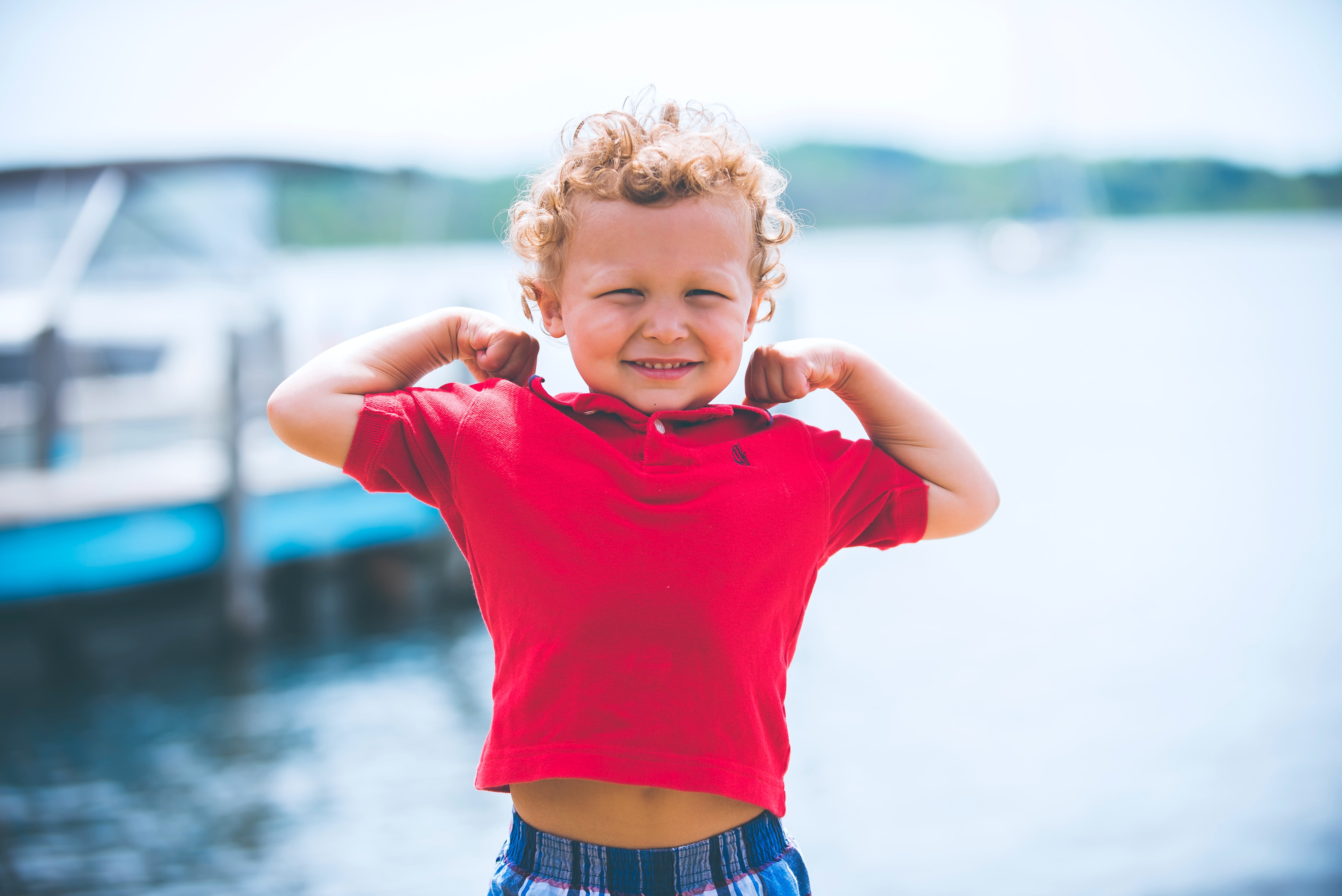 Photo a little boy showing his muscles