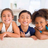 Photo of three children smiling.