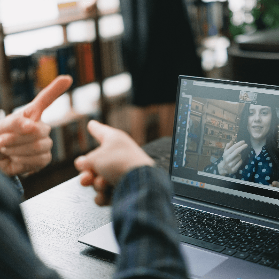 Person signing to another person on a computer