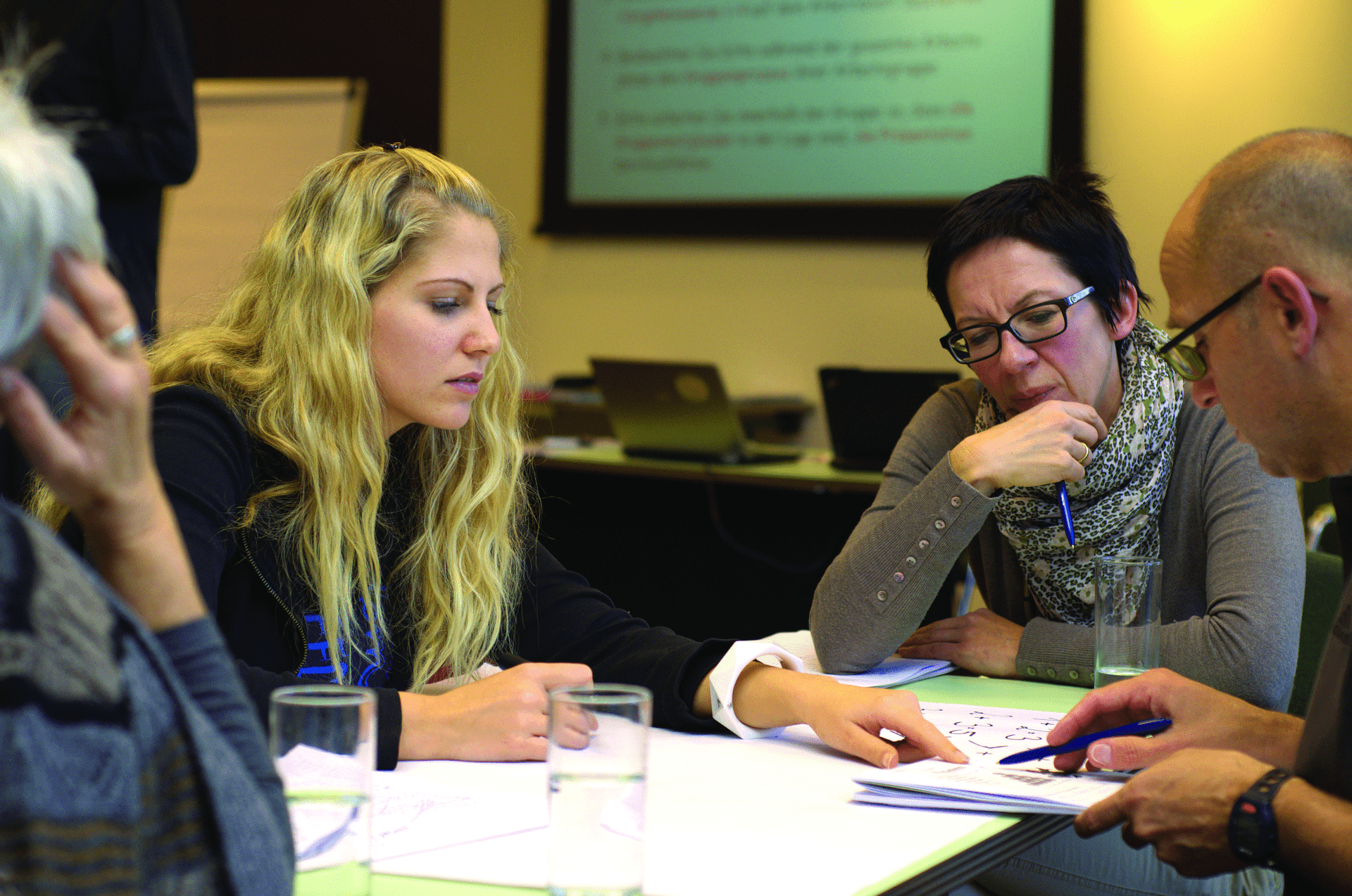 group of diverse people of all age ranges, leaning forward and engaging and discussing issues with one another