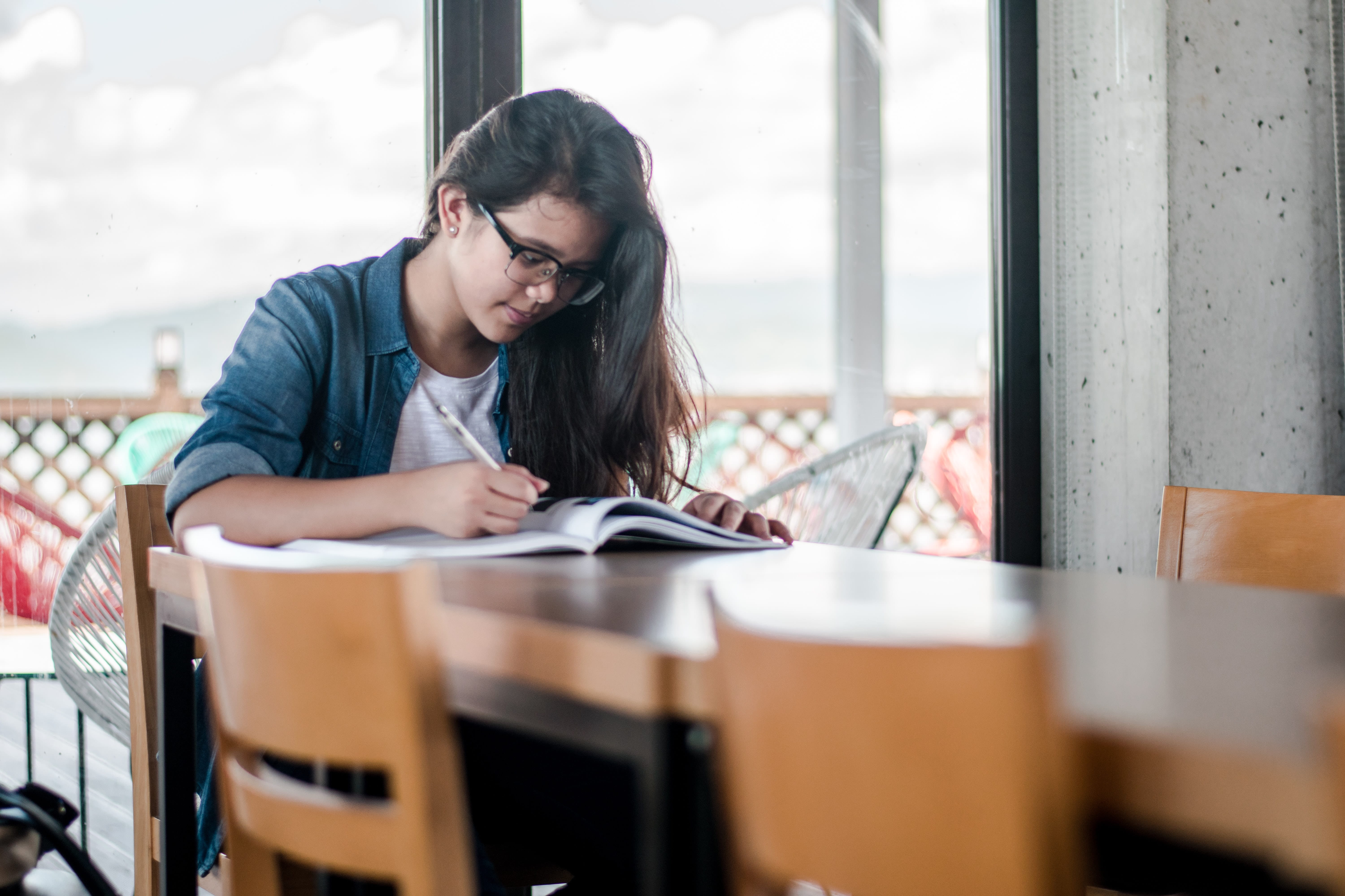 Photo of a teenage girl studying at a desk.
