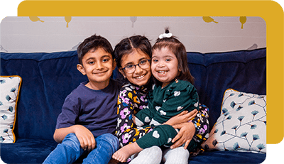 3 young siblings on a couch