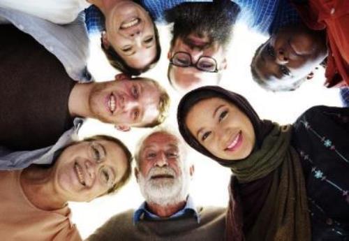 People in circle looking down into camera