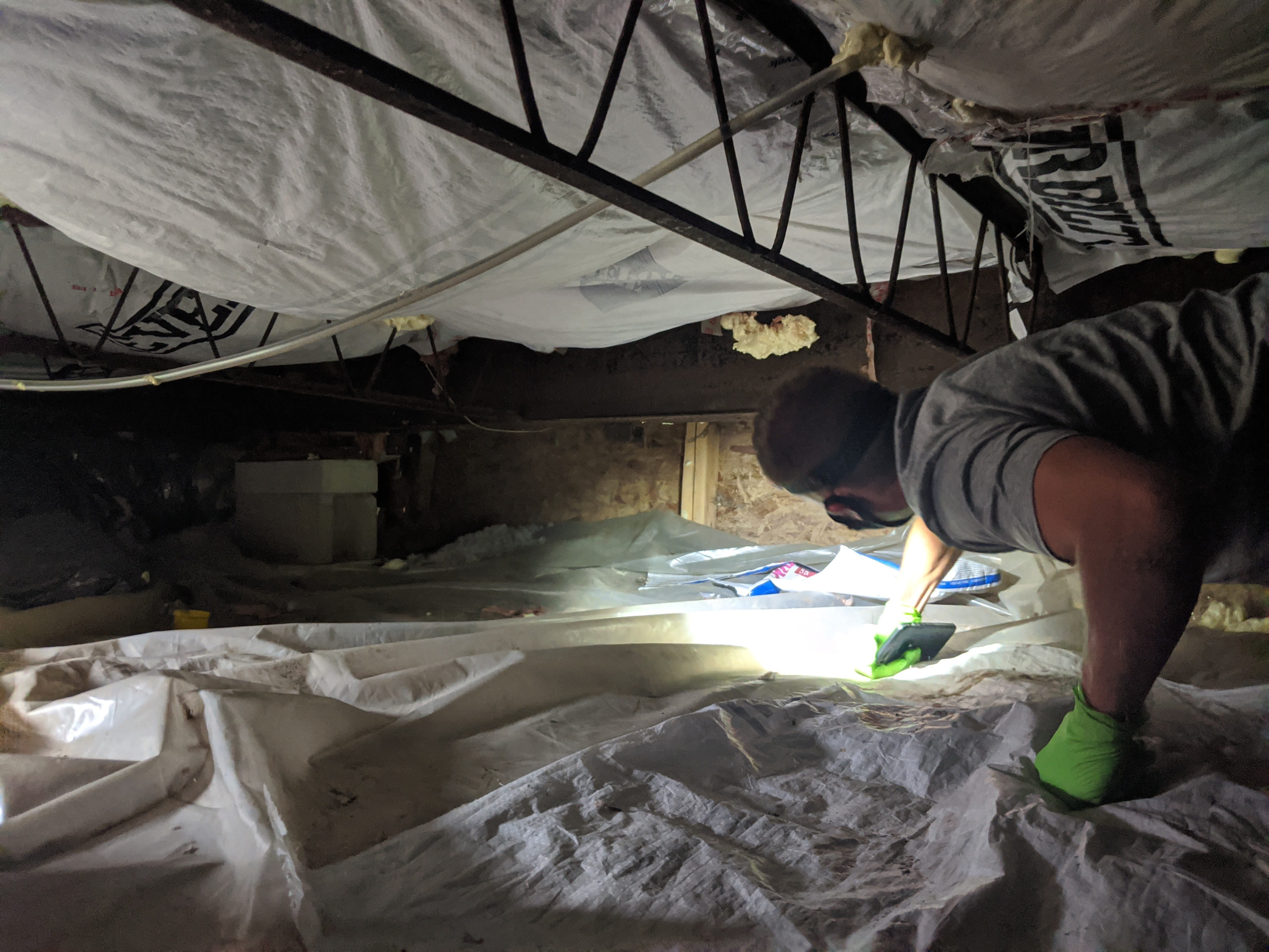 A Quality Control Inspector checking the crawlspace