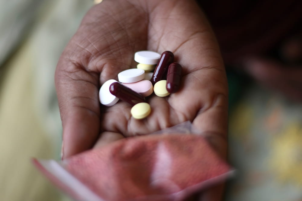 Hand with pills to treat TB.