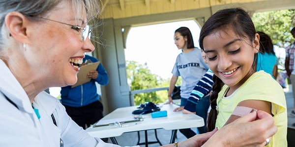 Doctor putting bandage on child, Care Delivery Calendar