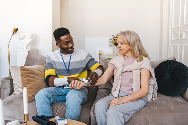 man taking woman's blood pressure