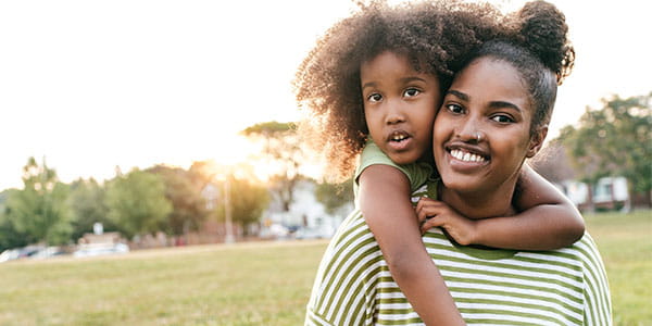 Woman with little girl on her back