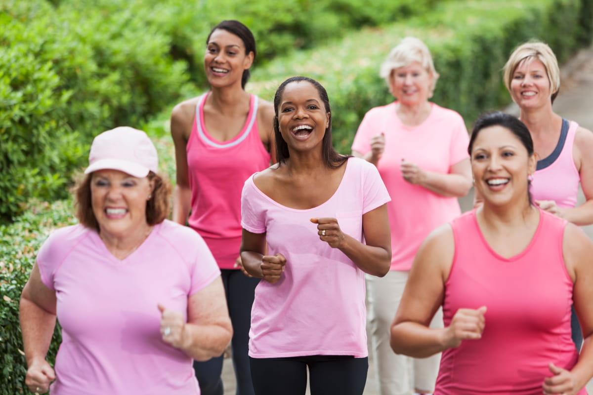 Women of a range of ages and ethnicities wearing pink and walking for the cause