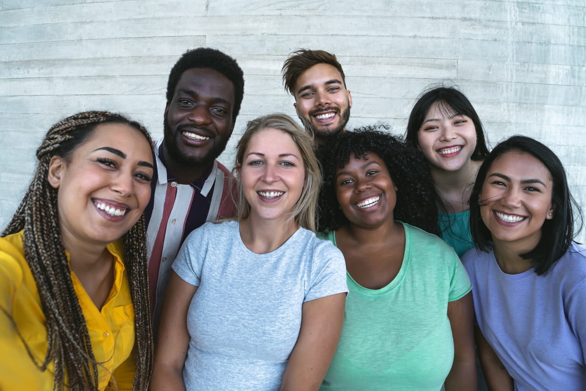 Group of millennial, multi-racial friends smiling for the camera