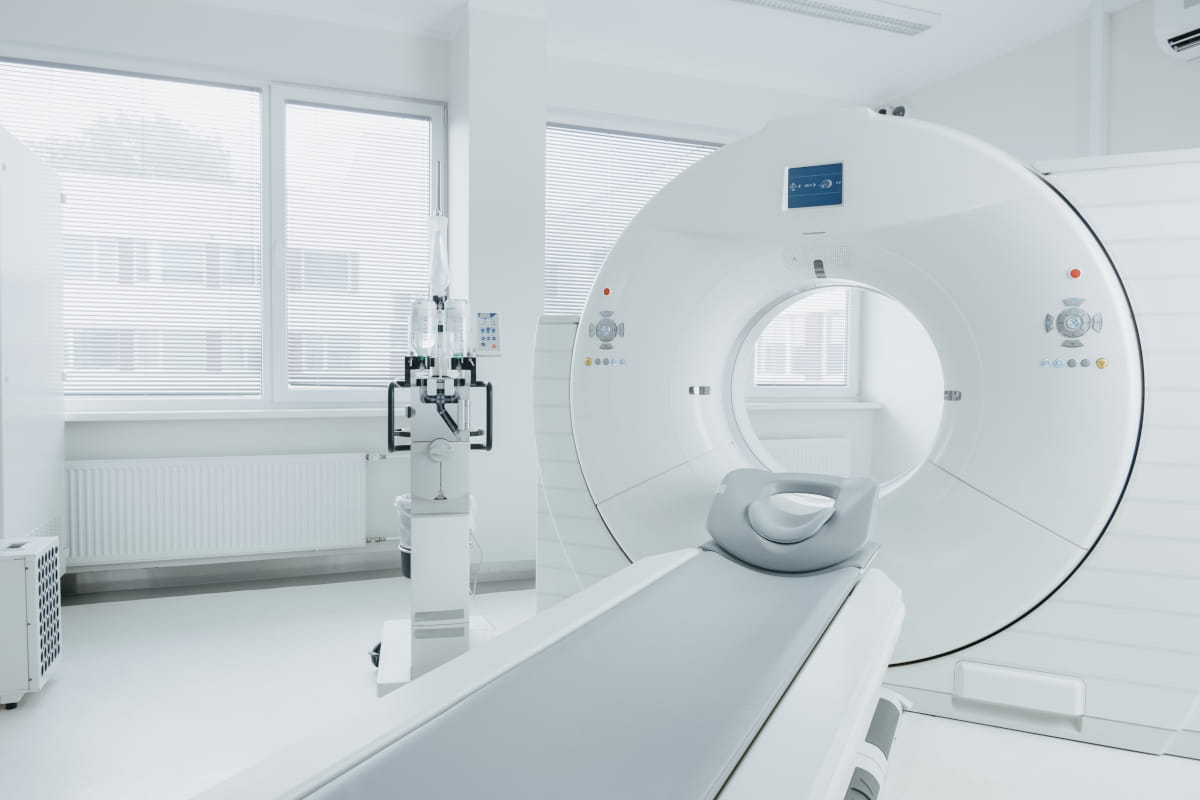 Medical computed tomography (CT) scanner in a white, modern hospital exam room