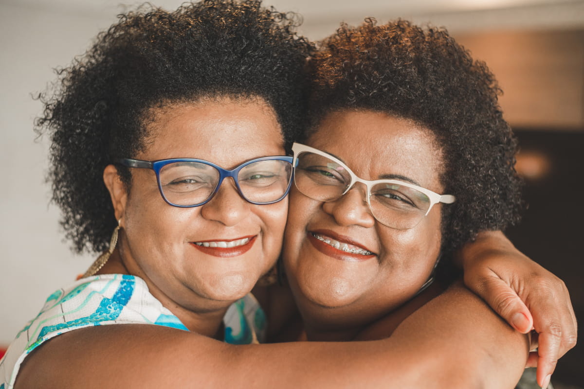 Two African American women embracing - happy!