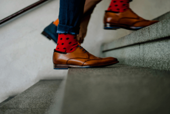 close-up of feet and colorful socks climbing stairway indoors