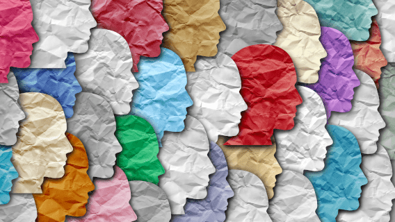 A collage of silhouettes of peoples' faces, cut from many different colors of paper