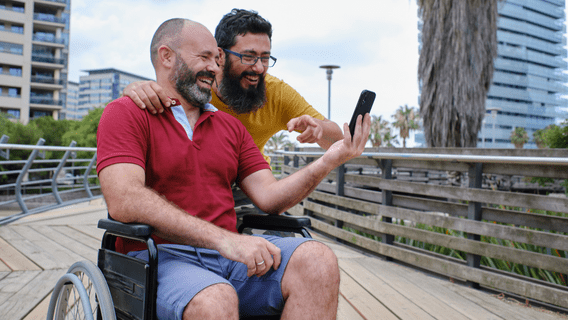 Two people smiling and looking at a phone together