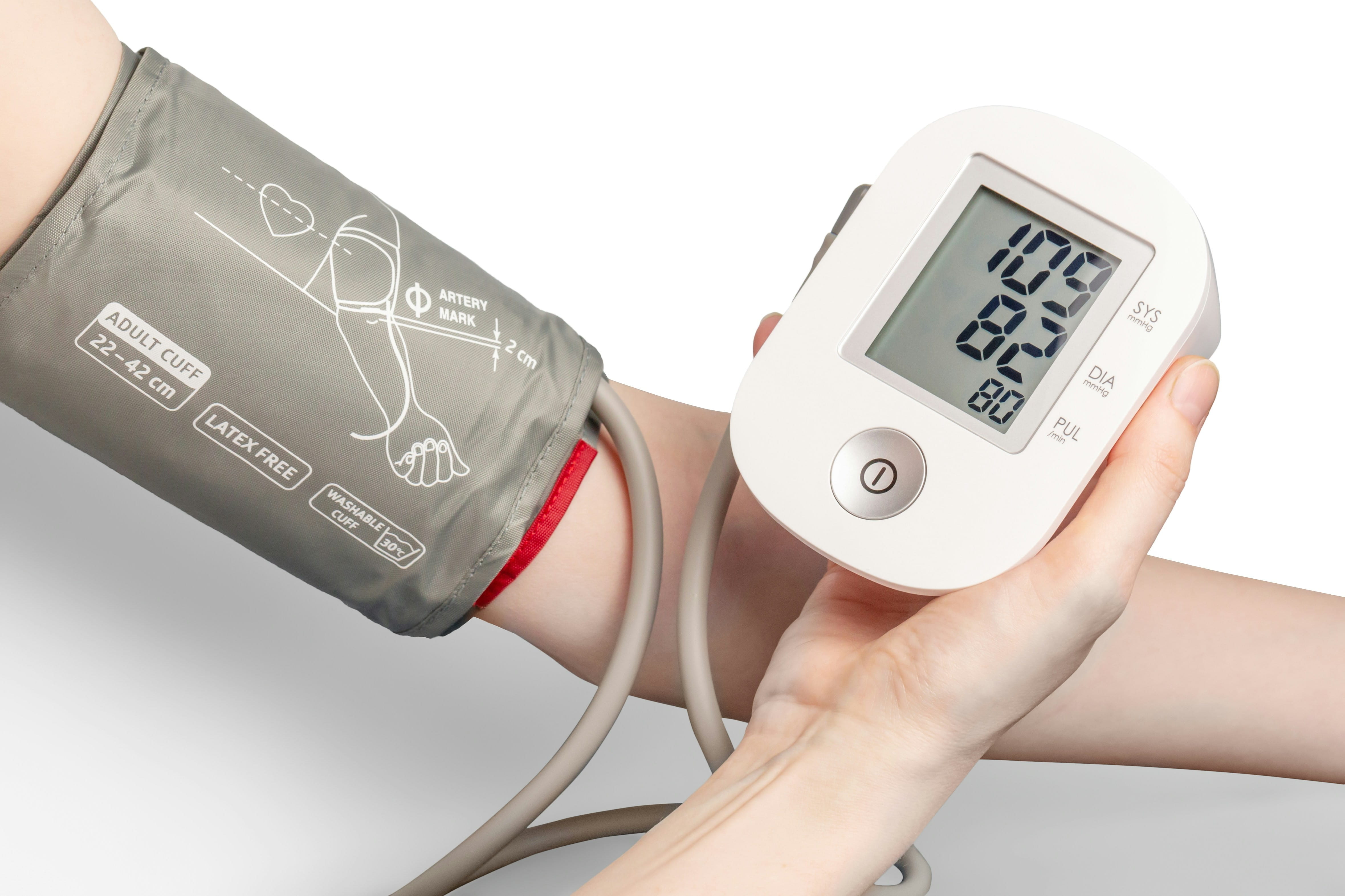 White individual taking blood pressure on left arm with an automatic reader