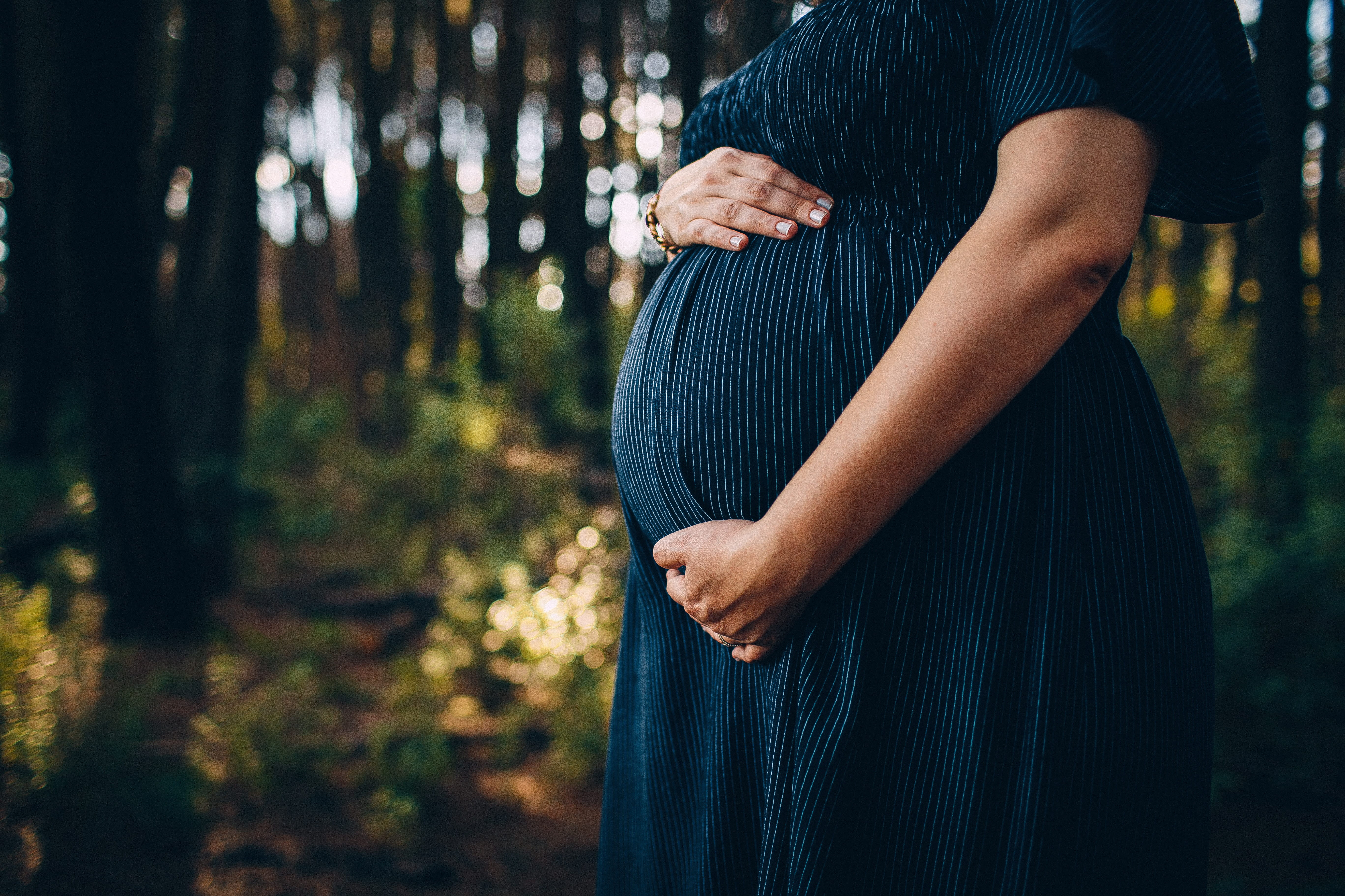 Pregnant person holding their belly