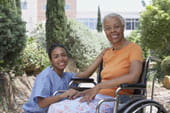 woman in wheelchair with helper