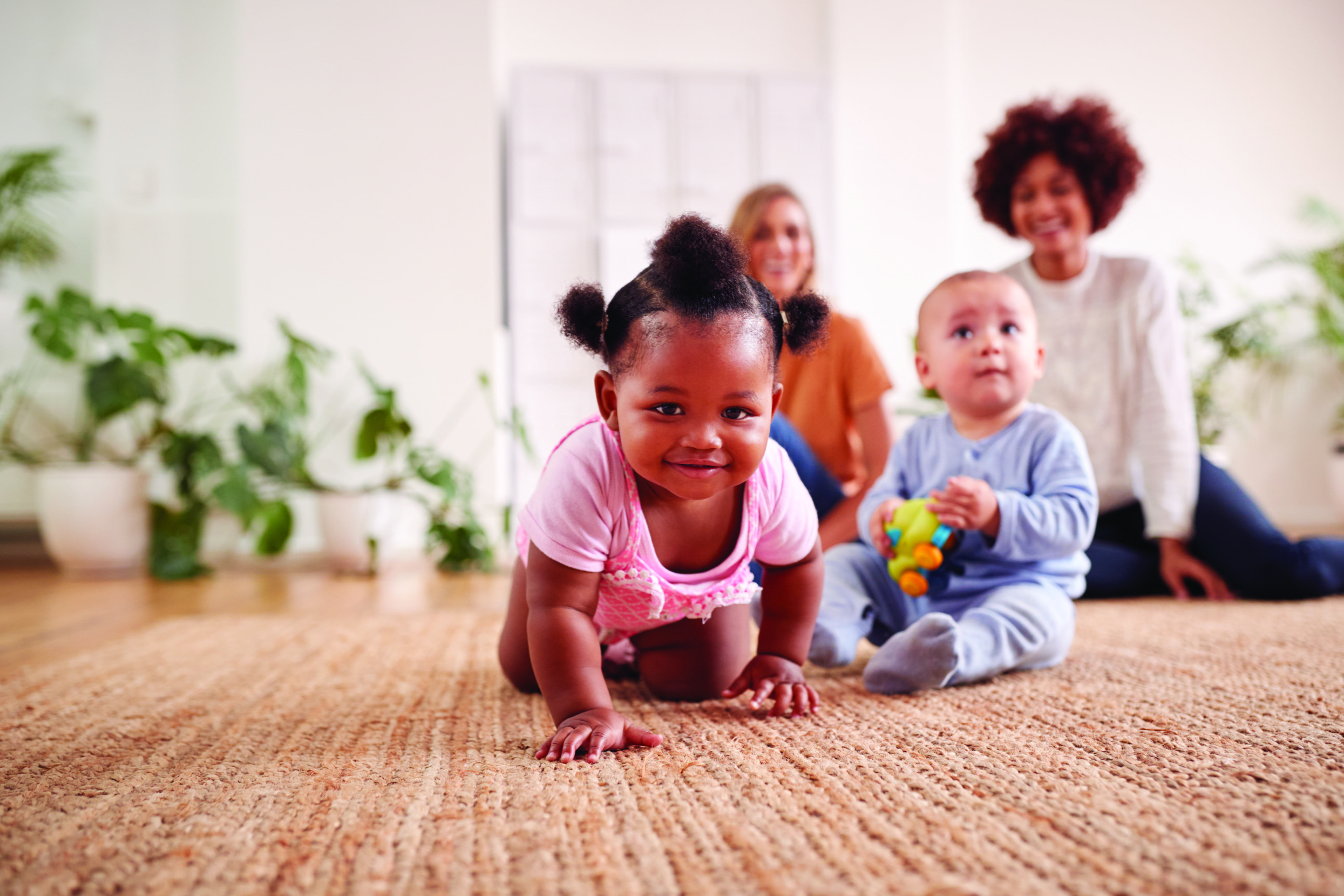 Infants and babies playing near two adults