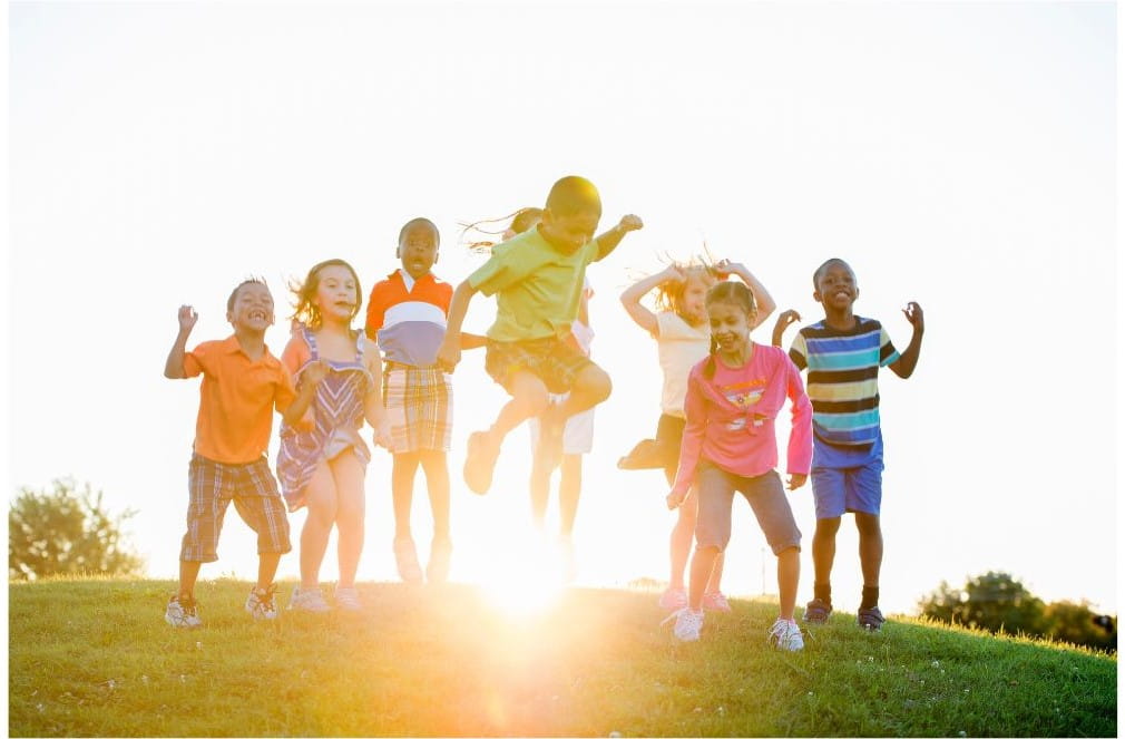 image of children playing outside with sun behind them