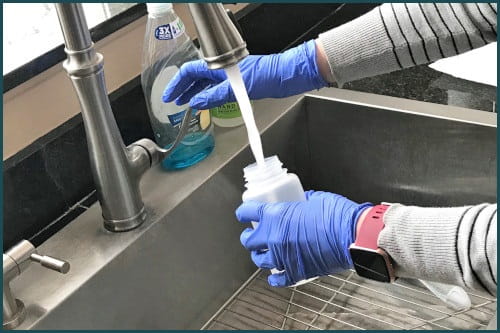 Person filling a sample bottle with tap water