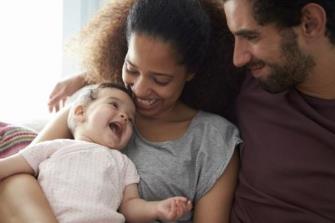 Mother and father smiling at their baby