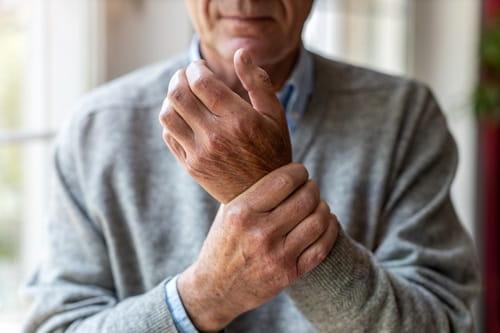 Man rubbing his wrist as though in pain
