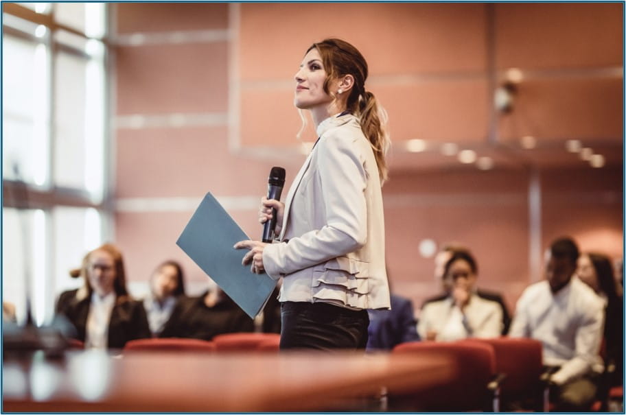 Woman standing up to give a presentation in front of a small audience