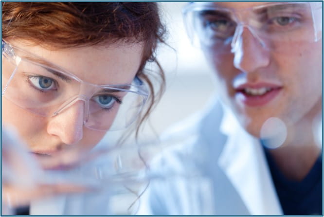 Two scientists looking at an object which is out of focus