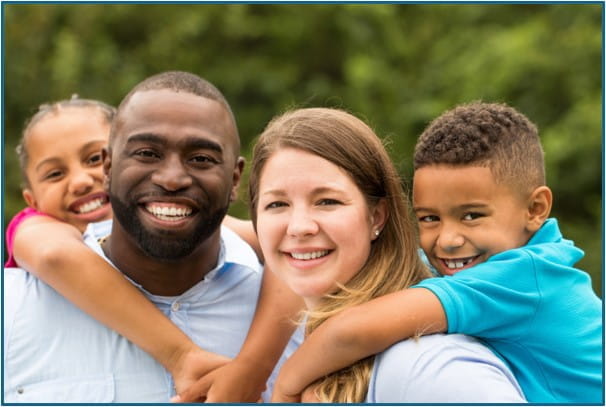 Family of four smiling into the camera