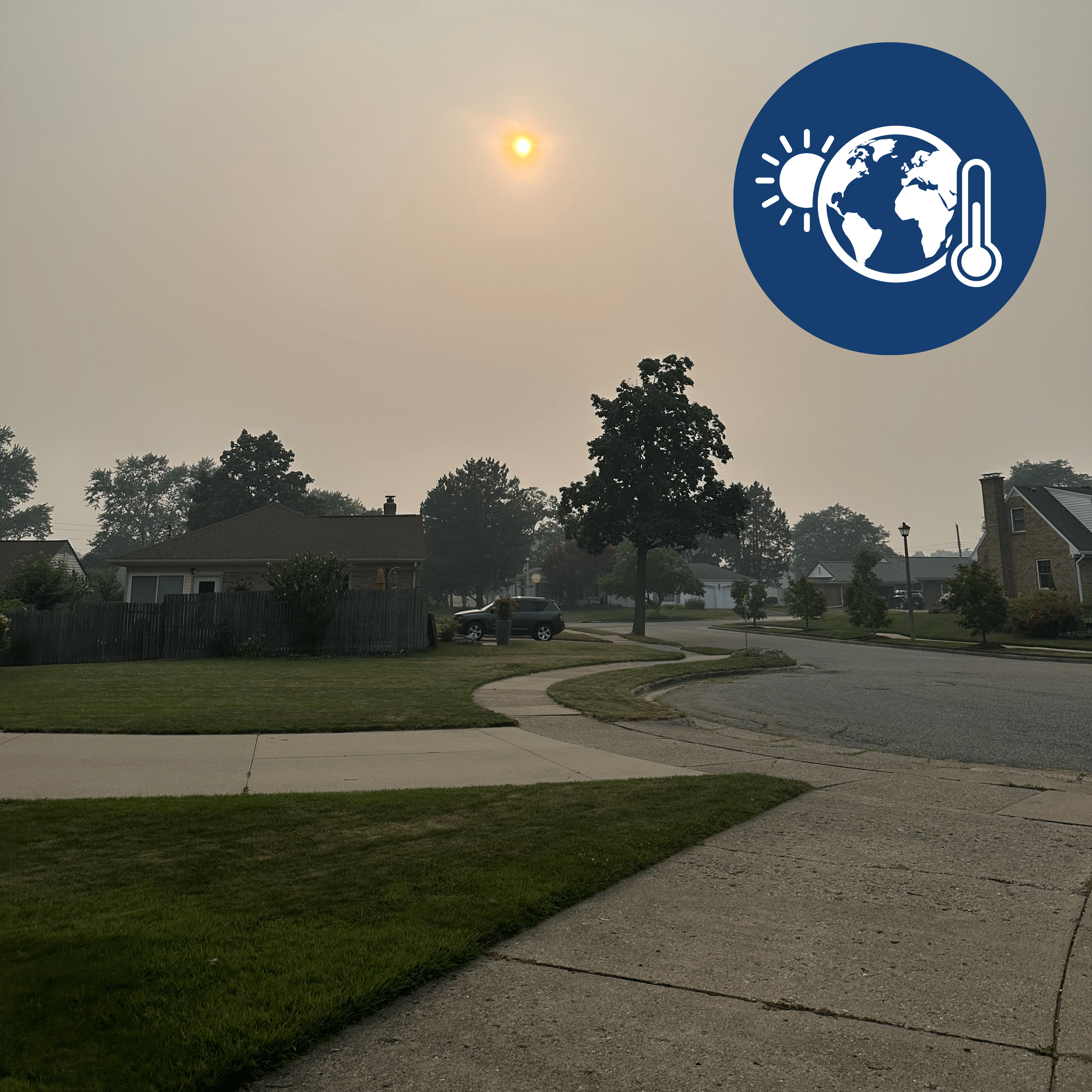 A residential street on a hazy day, with a climate change icon in the corner of the image