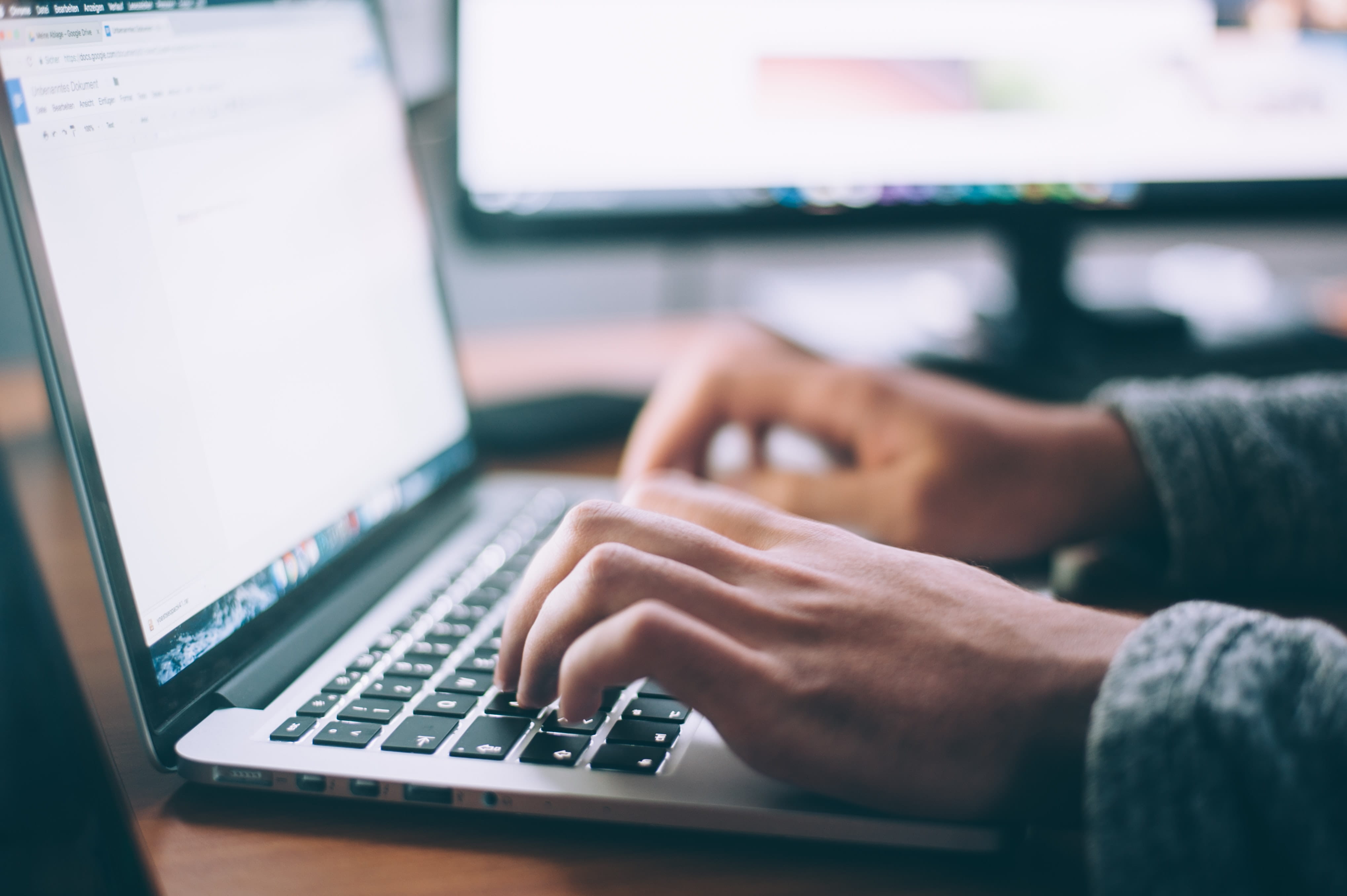 Photo of a person typing on a laptop.