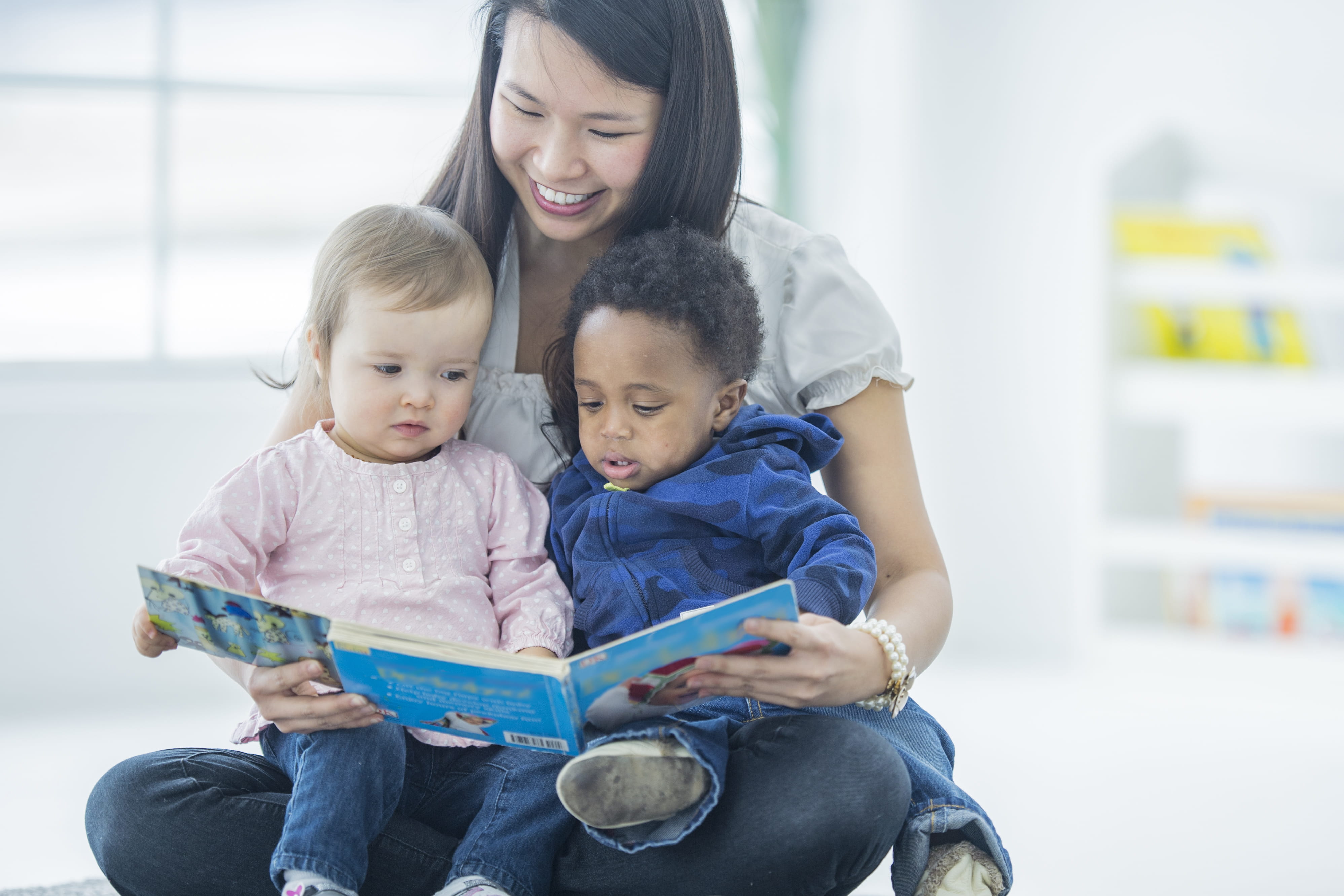 woman with two children reading