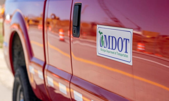 A red MDOT work truck with the department logo on the door.