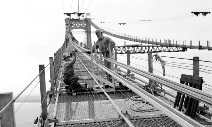 Personnel apprentices, brothers Newell and Henry Brown, on catwalk of the Mackinac Bridge. They are the sons of Capt. R.C. Brown who was in charge of cable wire splice testing.